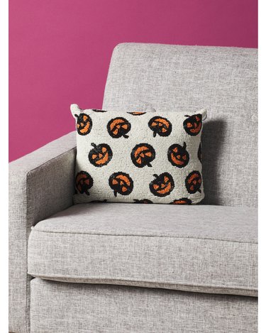 Beaded Jack-O-Lantern Pillow from HomeGoods. The pillow is mostly off-white with little black and orange jack-'o-lanters on it.