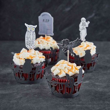 Halloween Cupcake Set from Sur La Table against a dark gray background. There are cupcake liners, wraps and picks in four different styles.