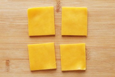 Cut slices of cheddar cheese into squares