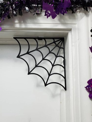 Spiderweb Corner Decor from Etsy. It's 6 inches wide and can be hung with double-sided tape.