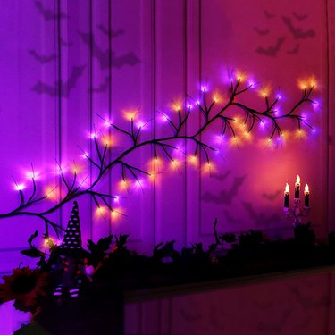 Orange & Purple LED Halloween Willow Branches Arranged Over a Fireplace Mantel.