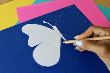 Tracing butterfly on blue card stock