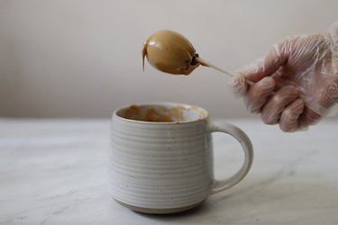 Dipping cake pop into melted peanut butter candy