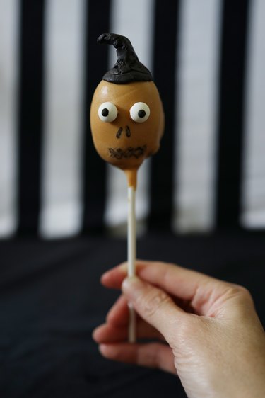 Holding a "Beetlejuice" shrunken head cake pop