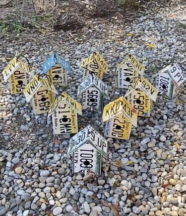 11 birdhouses made using folded license plates from Maine and New Jersey