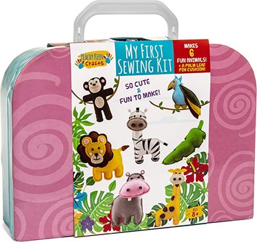 A pink carrying case that says, "My First Sewing Kit" and has images of stuffed animals on the cardboard wrapping.