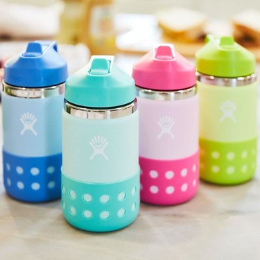 Four colorful Hydro Flask bottles in a row