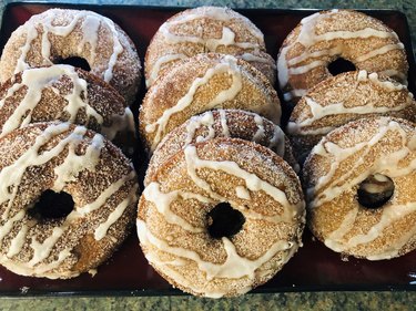 Brown donuts with cinnamon sugar coating and vanilla glaze