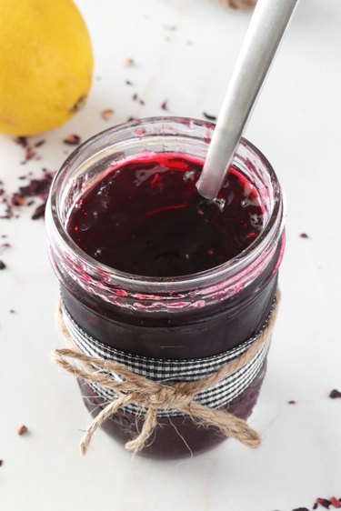 Hibiscus jelly in jar with spoon inside