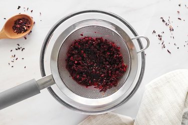 Straining hibiscus-infused water