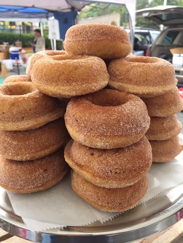 Stack of light brown donuts with cinnamon sugar coating