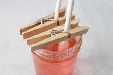 Lollipop sticks in a glass jar of sugar syrup