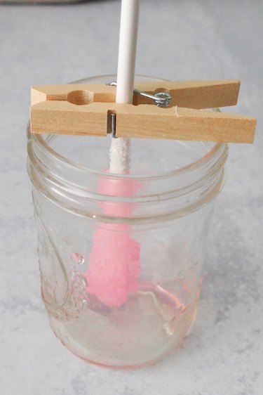 Pink rock candy drying in a glass jar
