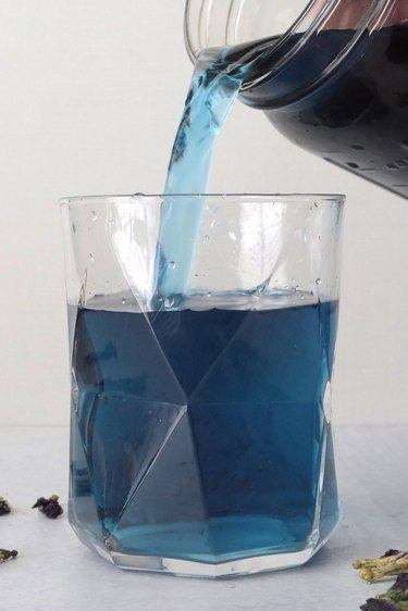 Pouring butterfly pea tea in a clear glass