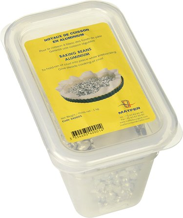 Plastic tub of aluminum pie weights from French manufacturer Matfer, shown on a white ground