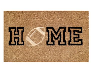 Doormat with the word "Home" and a football replacing the "O"