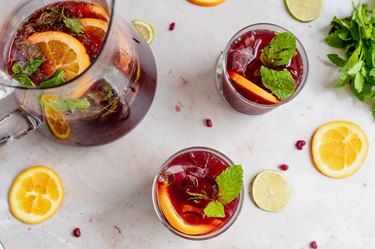 pomegranate citrus punch served in glasses next to a pitcher