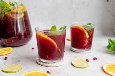 pomegranate citrus punch served in glasses next to a pitcher