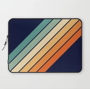 Navy laptop sleeve with multicolored retro stripes and a zipper opening at the top.