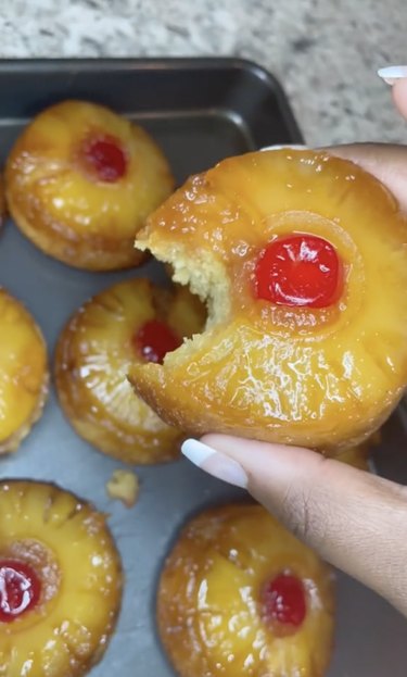 Pineapple upside-down cupcakes, including one with a bite taken out of it