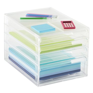 Four-drawer plastic organizer with paper inside and office supplies on top