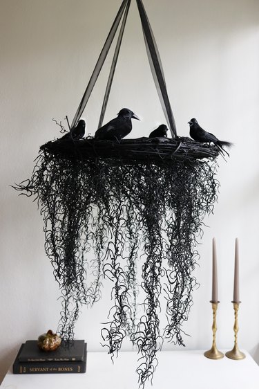 black Halloween wreath chandelier with crows hanging over table