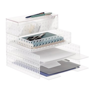 Stackable plastic shelves holding papers and office supplies
