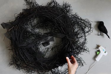 hot-gluing black crows to Halloween chandelier