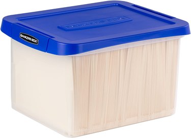 Plastic box with blue lid filled with folders