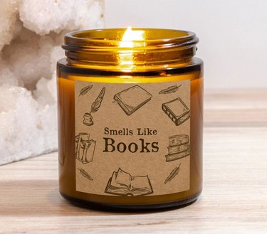 Brown amber glass jar candle reading "Smells Like Books"