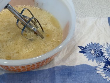 Whisking egg and vanilla with hand-held mixer.