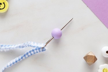 Add wooden bead to needle