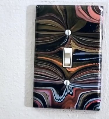 Colorful marbled light switch cover on a white wall