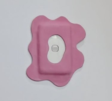 Pink abstract design around a plain white light switch