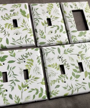 White light switch covers with green leaf patterns