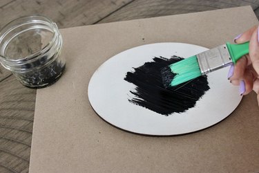 Painting on an oval with black paint