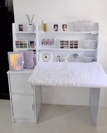 White desk with layer of fuzzy white carpeting on top