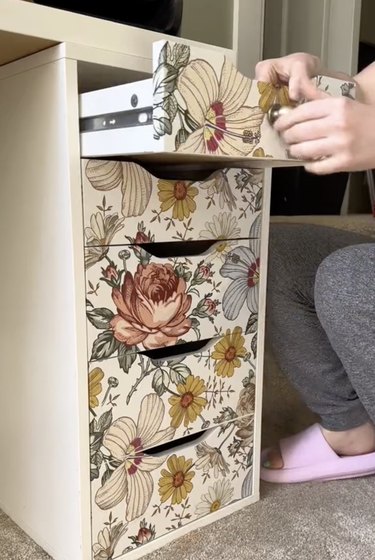 White desk drawers covered in floral wallpaper