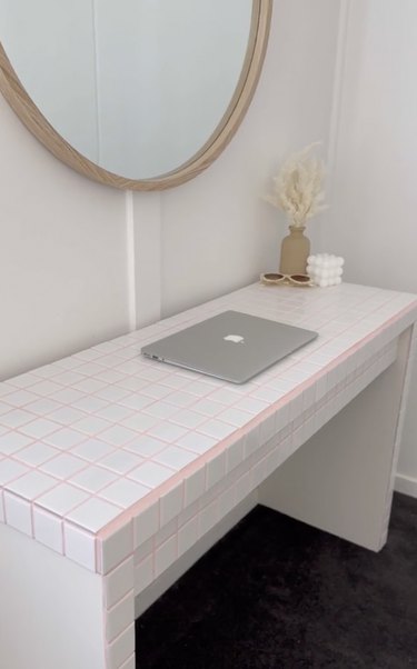 White tile desk with pink caulk