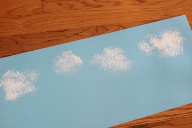 painting clouds on blue paper