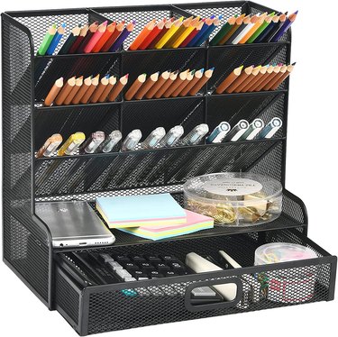 Black mesh organizer with several compartments and a drawer
