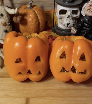 Orange bell peppers carved to resemble jack-o'-lanterns and filled with ground beef and cheese