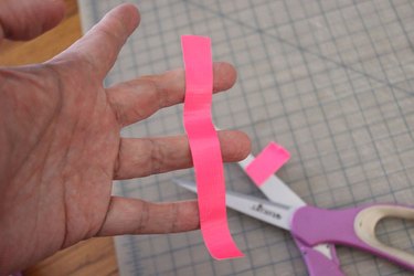 cutting strips of bright pink duct tape