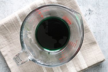 Green candle wax in a Pyrex cup
