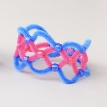 Pink and blue pipe cleaner bracelet on white background