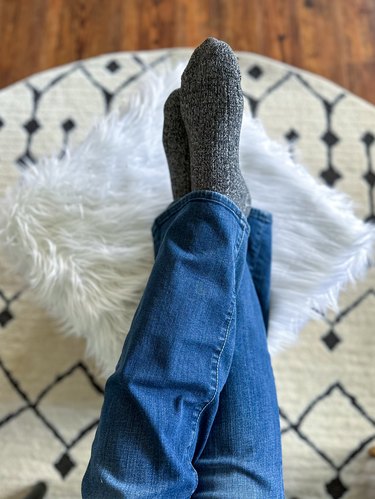 feet resting on finished faux fur ottoman pouf