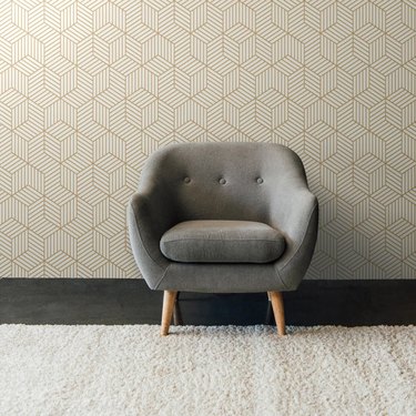 Removable wallpaper from Dormify in a gold, geometric pattern that looks like interlocking, three-dimensional cubes.