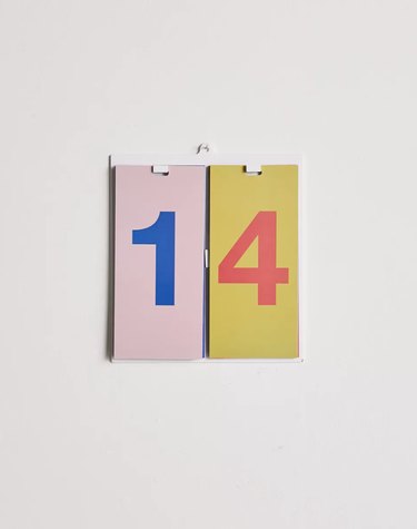 Colorful number 14 on a small wall calendar. The one has a pink background and a blue number, and the four has a yellow background and a coral colored number.