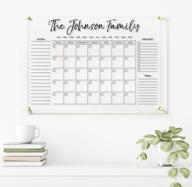 Acrylic, personalized white wall calendar hanging over desk