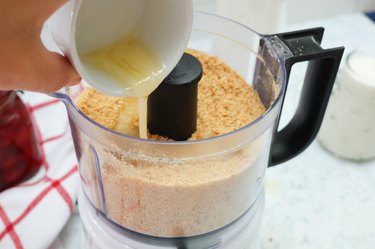 adding butter to ground graham crackers